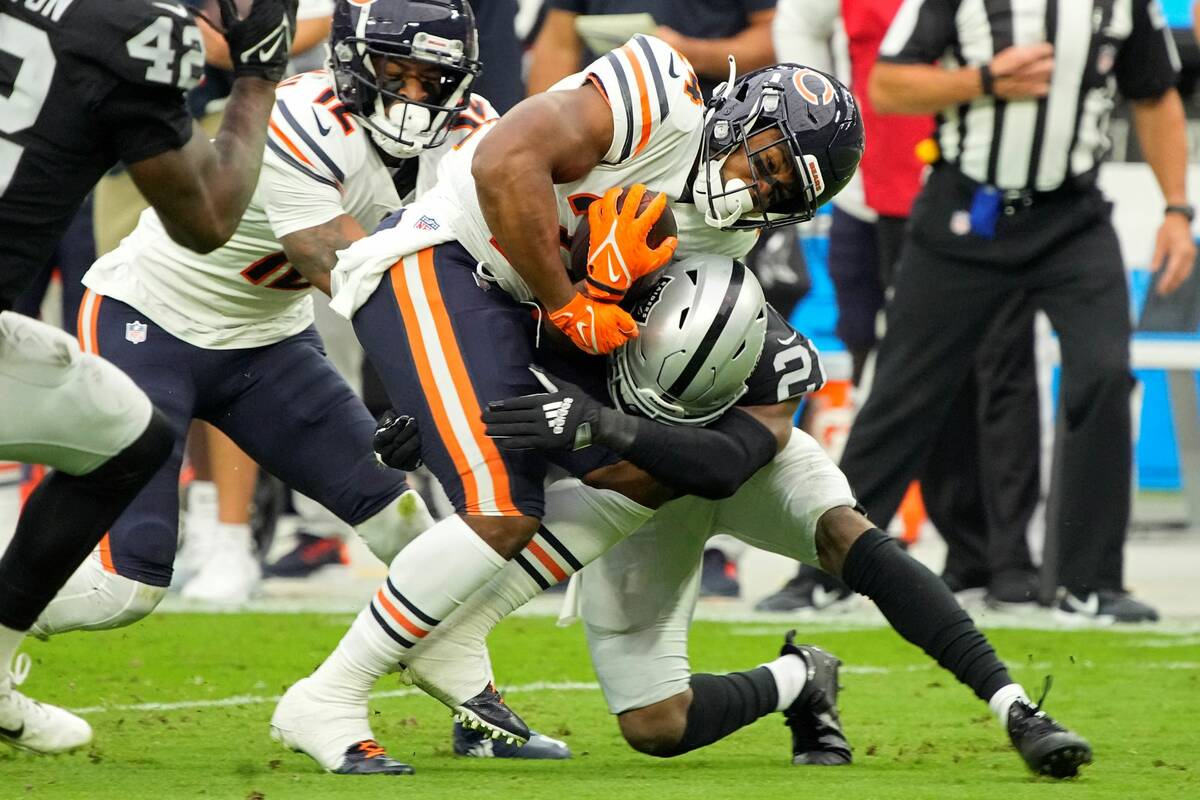 Las Vegas Raiders cornerback Amik Robertson (21) tackles Chicago Bears running back Khalil Herb ...