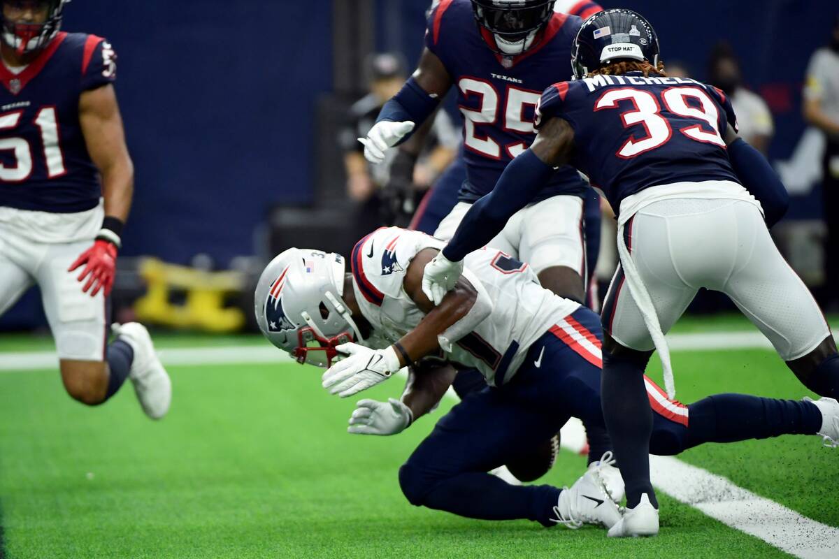 New England Patriots running back Damien Harris, bottom, fumbles the ball at the goal line as h ...