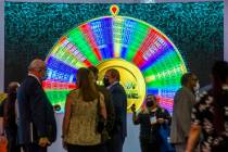A giant Wheel of Fortune spins as attendees gather in the IGT gaming space during day 3 at the ...