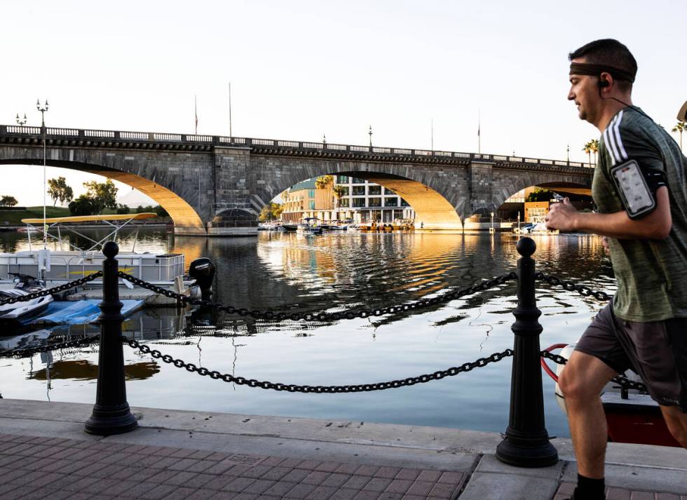 A runner jogs past London Bridge on Sunday, Oct. 3, 2021, in Lake Havasu, Ariz. (Bizuayehu Tesf ...