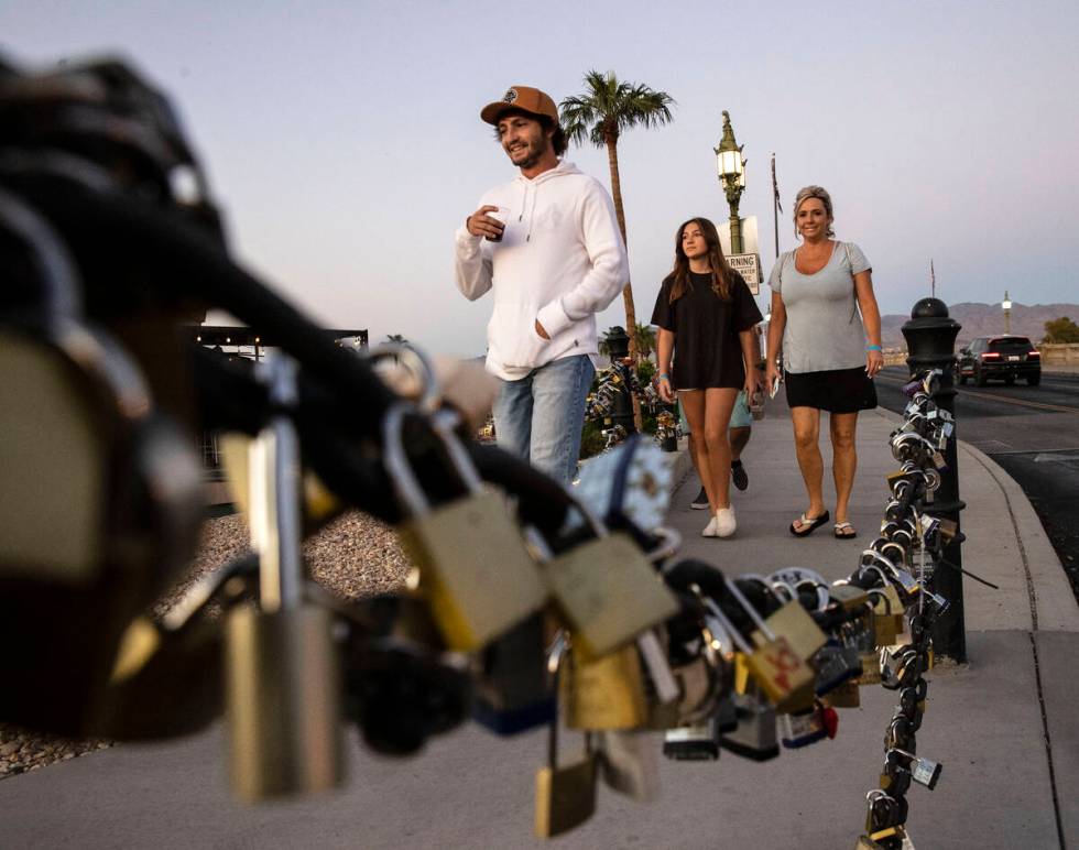 Love padlocks left by visitors are seen as pedestrians walk across London Bridge on Saturday, O ...