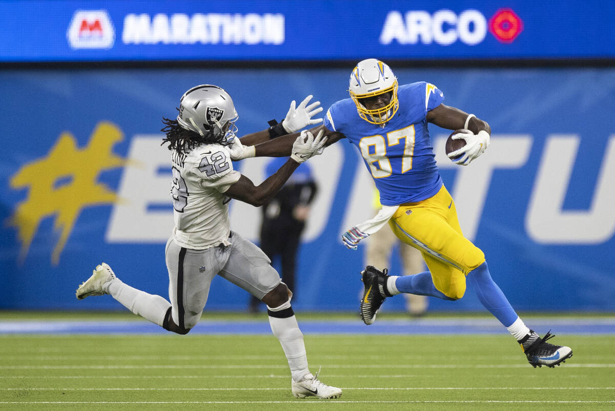 Los Angeles Chargers tight end Jared Cook (87) stiff arms Raiders inside linebacker Cory Little ...