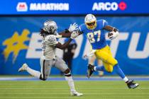 Los Angeles Chargers tight end Jared Cook (87) stiff arms Raiders inside linebacker Cory Little ...
