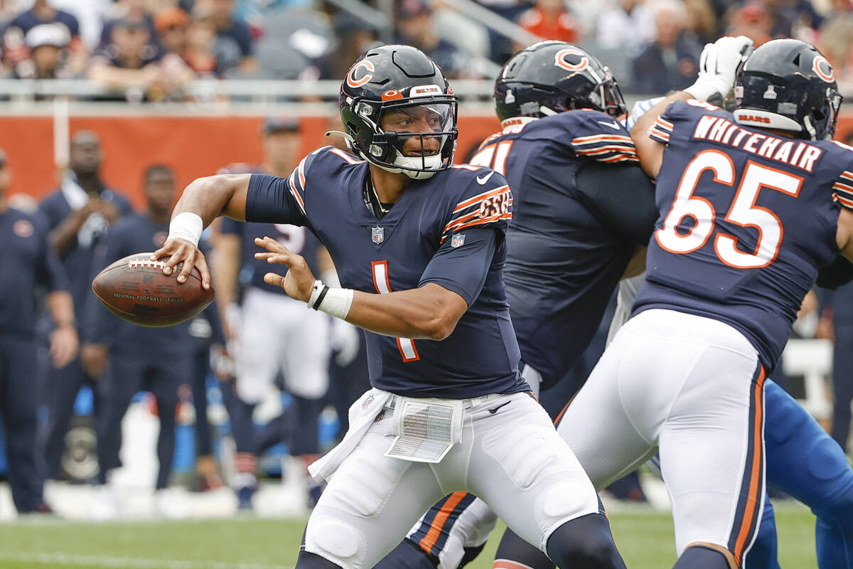 Chicago Bears quarterback Justin Fields (1) looks to pass the ball during the first half of an ...