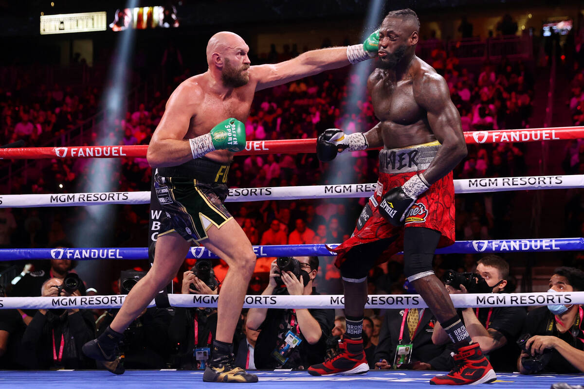 Tyson Fury, left, connects a punch against Deontay Wilder in the eight round of the WBC Heavywe ...