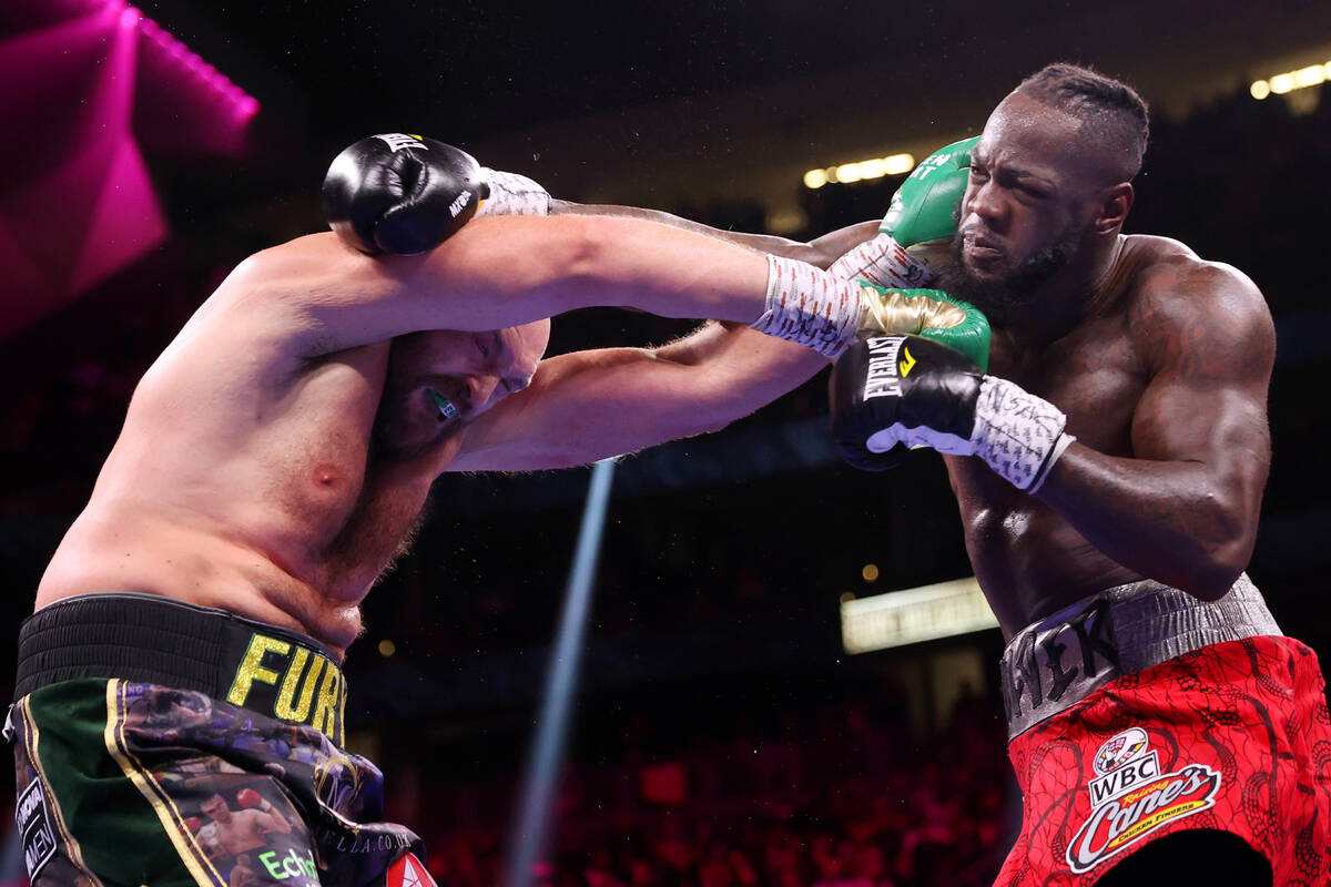Tyson Fury, left, and Deontay Wilder, battle in the third round of a WBC Heavyweight World Cham ...