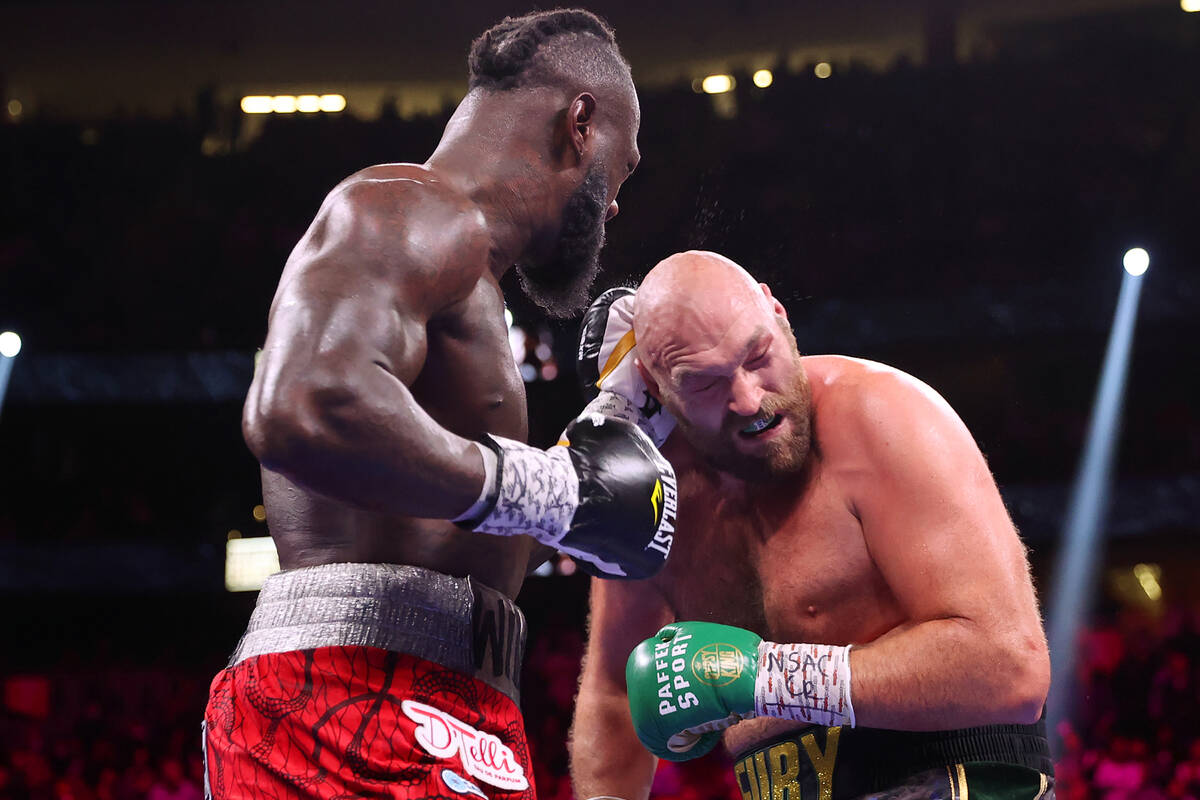 Deontay Wilder, left, connects a punch against Tyson Fury in the fourth round of a WBC Heavywei ...