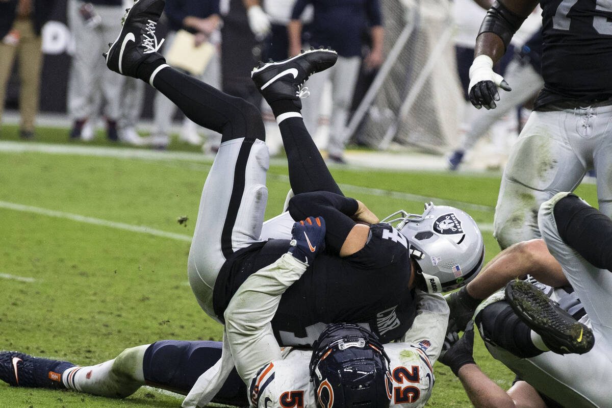 Raiders quarterback Derek Carr (4) sucked by Chicago Bears outside linebacker Khalil Mack (52) ...