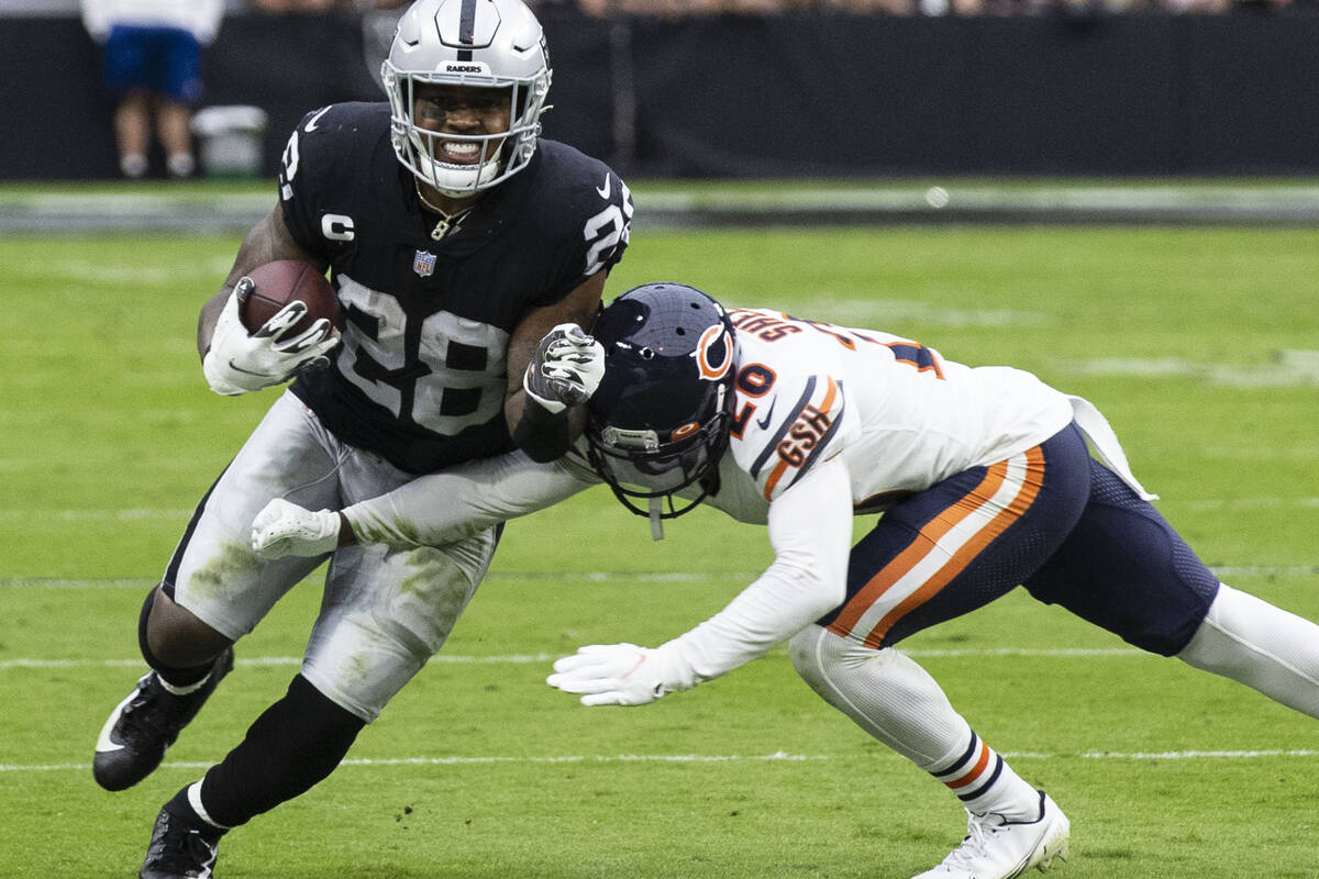 Raiders running back Josh Jacobs (28) eludes Chicago Bears cornerback Duke Shelley (20) during ...
