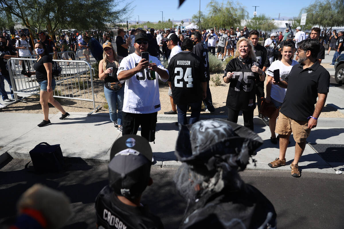 Fans take photos outside of Allegiant Stadium in Las Vegas before the start of an NFL football ...