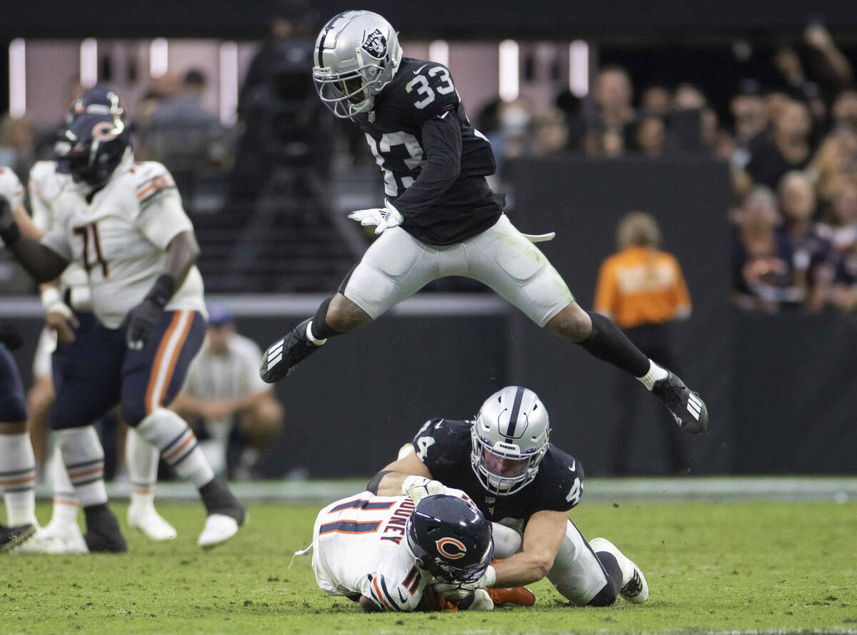 Raiders safety Roderic Teamer (33) leaps over Raiders inside linebacker Nick Kwiatkoski (44) an ...