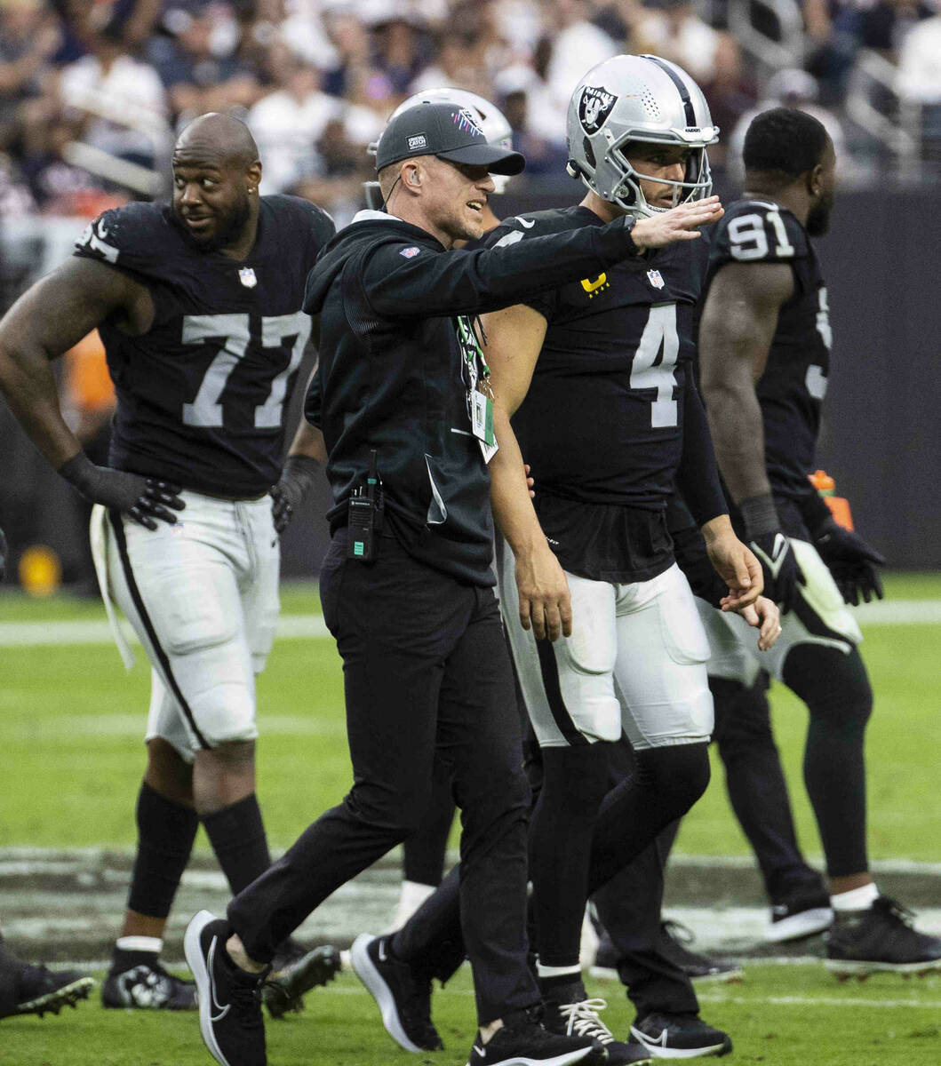 Raiders quarterback Derek Carr (4) lead out of the field during the second half of an NFL footb ...