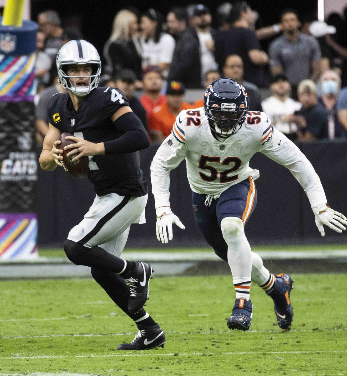 Raiders quarterback Derek Carr (4) chased by Chicago Bears outside linebacker Khalil Mack (52) ...