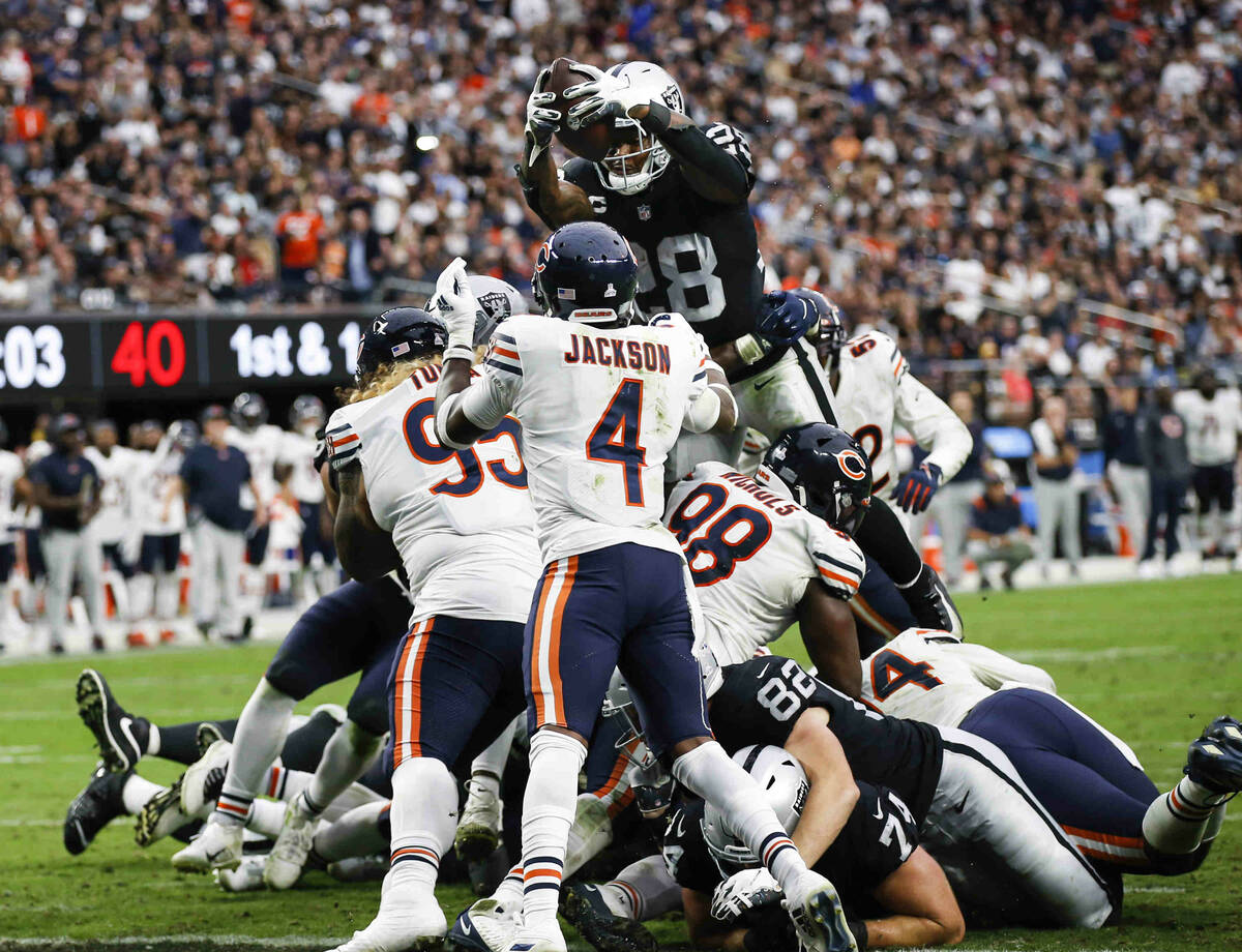 Raiders running back Josh Jacobs (28) leaps over to score a touchdown against the Chicago Bears ...