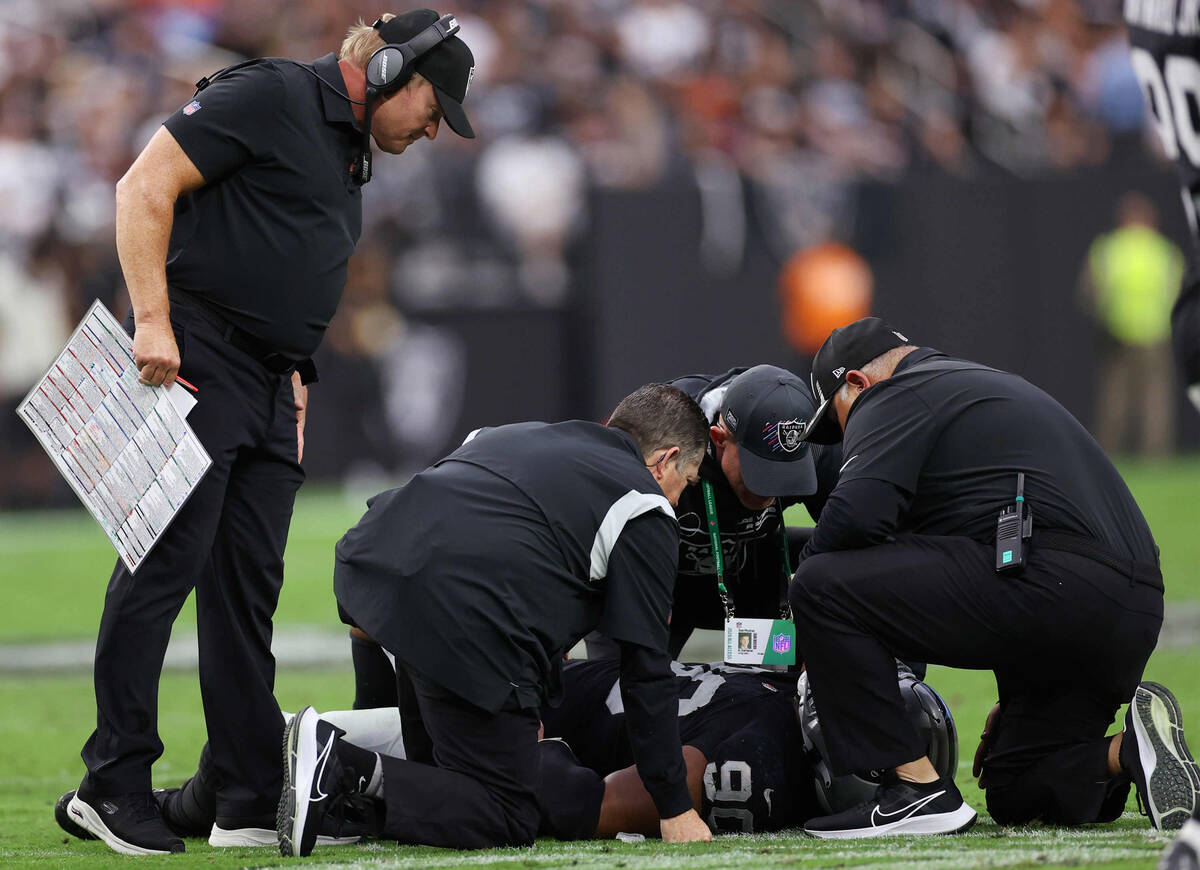 Raiders Coach Jon Gruden checks on injured player defensive tackle Johnathan Hankins (90) durin ...