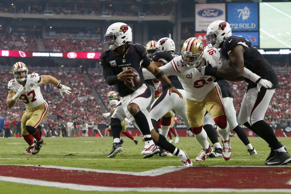 Arizona Cardinals quarterback Kyler Murray (1) eludes the reach of San Francisco 49ers defensiv ...
