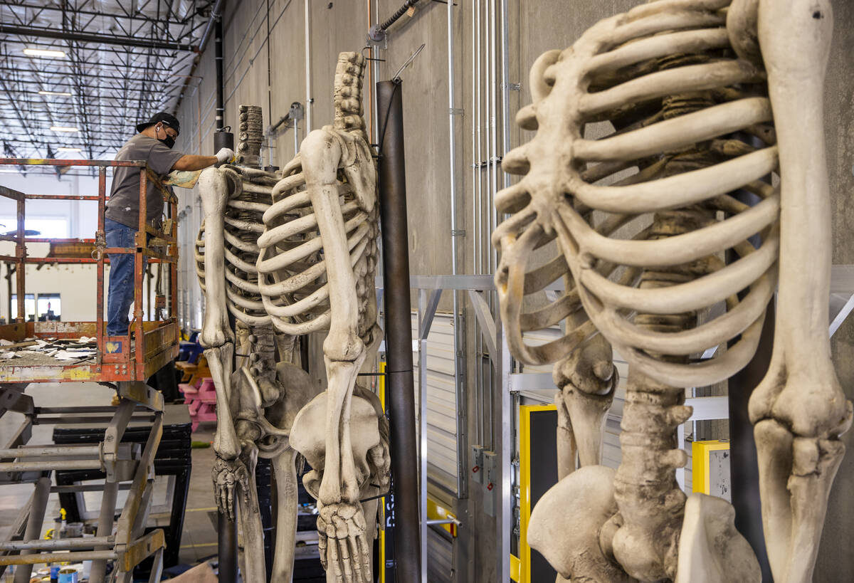 Jose Cardenas paints giant skeleton bodies within the Electric Daisy Carnival warehouse as they ...