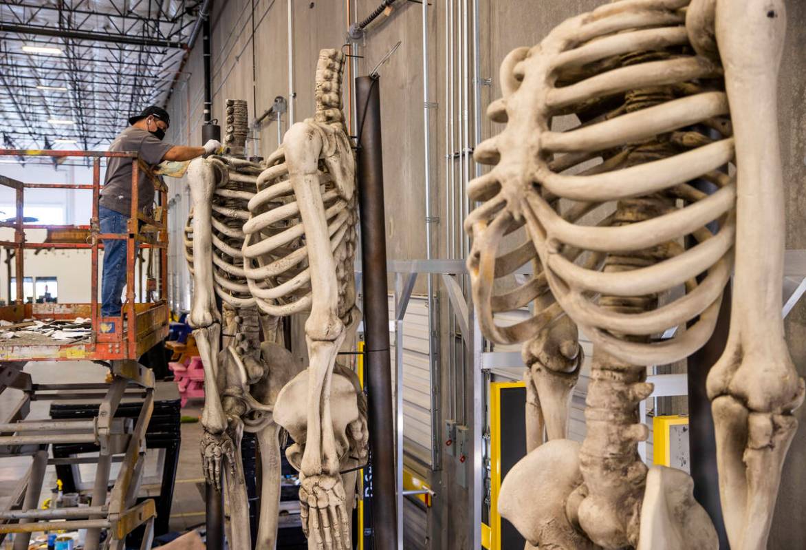 Jose Cardenas paints giant skeleton bodies within the Electric Daisy Carnival warehouse as they ...