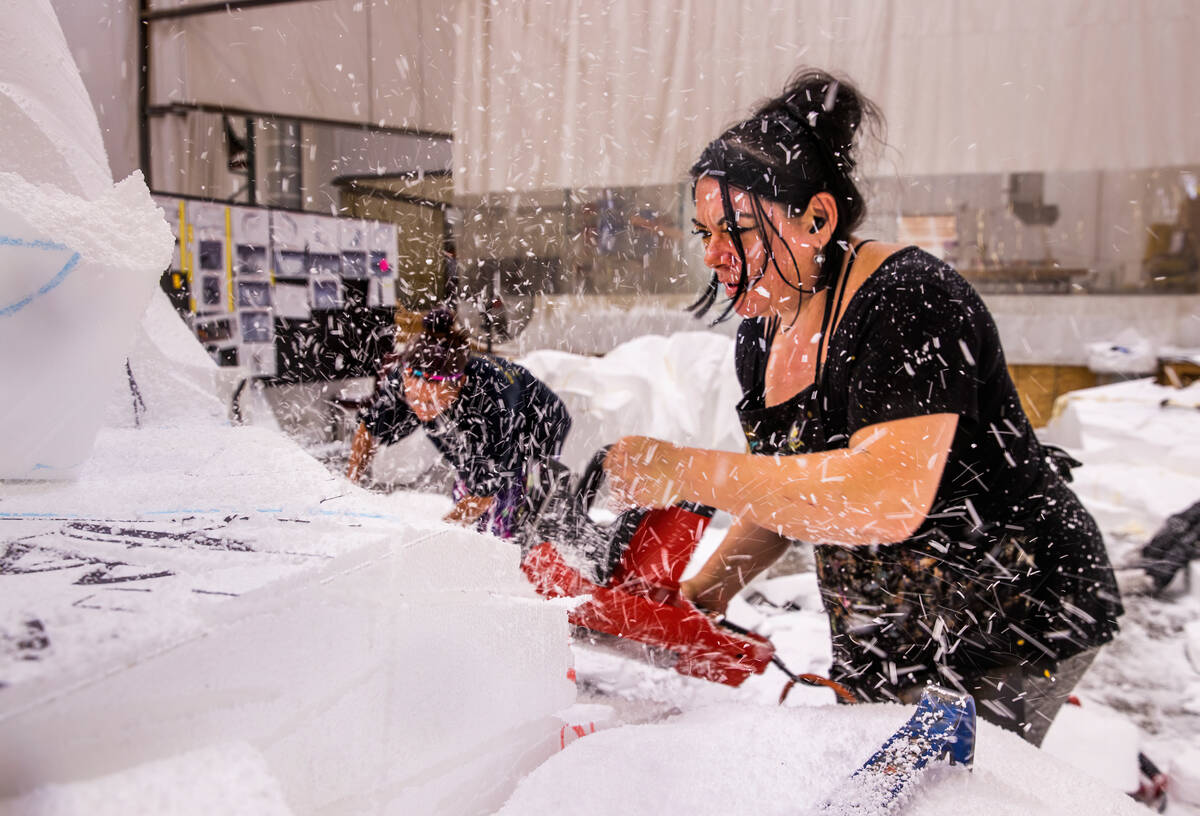 Evelyn Astudillo, right, sends pieces of styrofoam flying from her electric carver while foam s ...