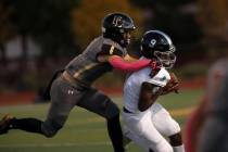 Faith Lutheran School's Blake Driscoll (6) tries to stop Desert Pines High School's Michael Kea ...