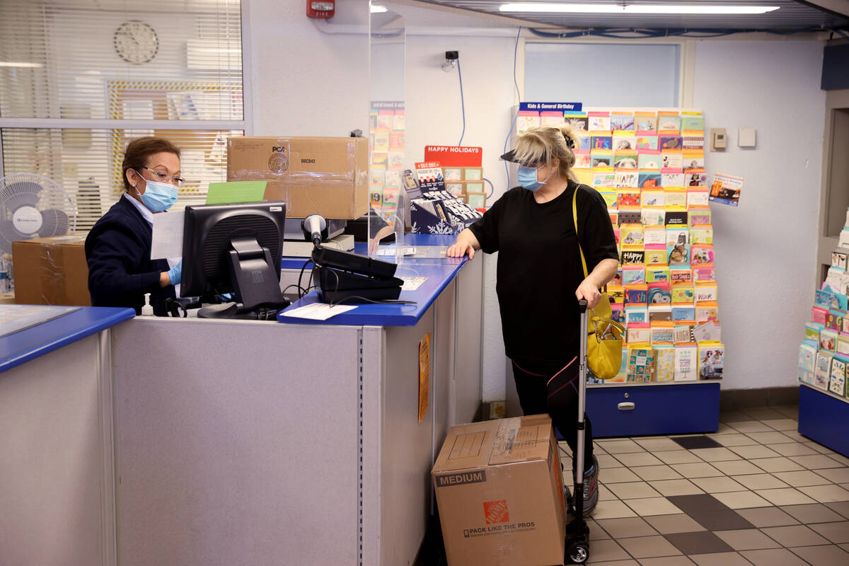 Imelda Brown helps a customer who declined to give her name ship packages at the main Las Vegas ...