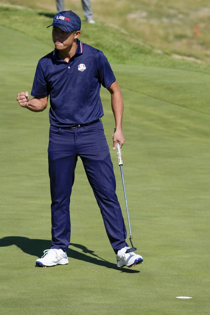 Team USA's Collin Morikawa reacts after making a putt on the 17th hole during a foursomes match ...