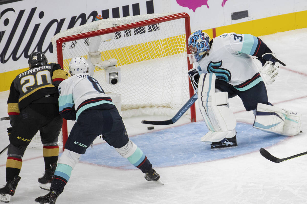 Vegas Golden Knights center Chandler Stephenson (20) scores a goal against Seattle Kraken goalt ...