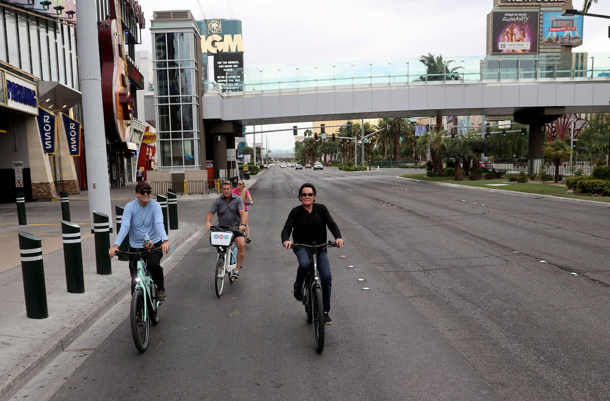 Mr. Las Vegas Wayne Newton, right, rides a bicycle on the Strip in Las Vegas with, from left, L ...