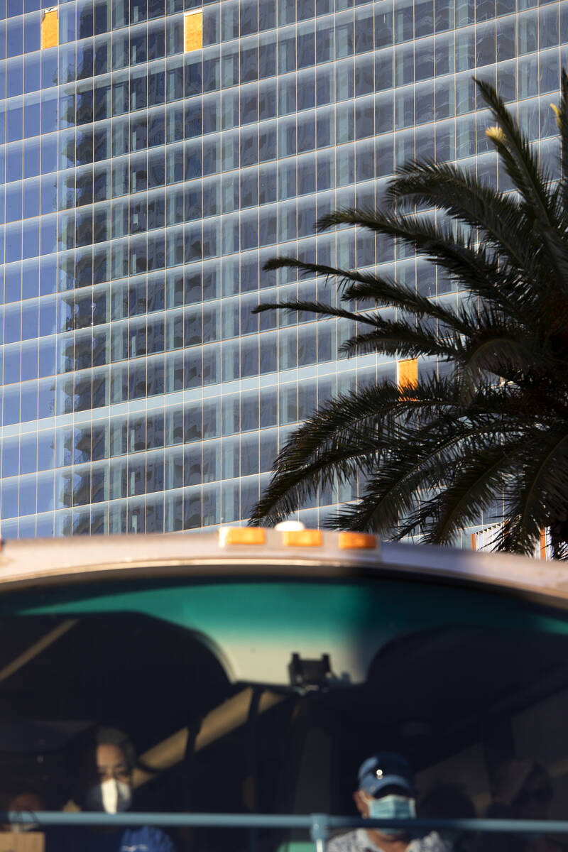Windows are missing in the unfinished former Fontainebleau building as a double-decker bus trav ...