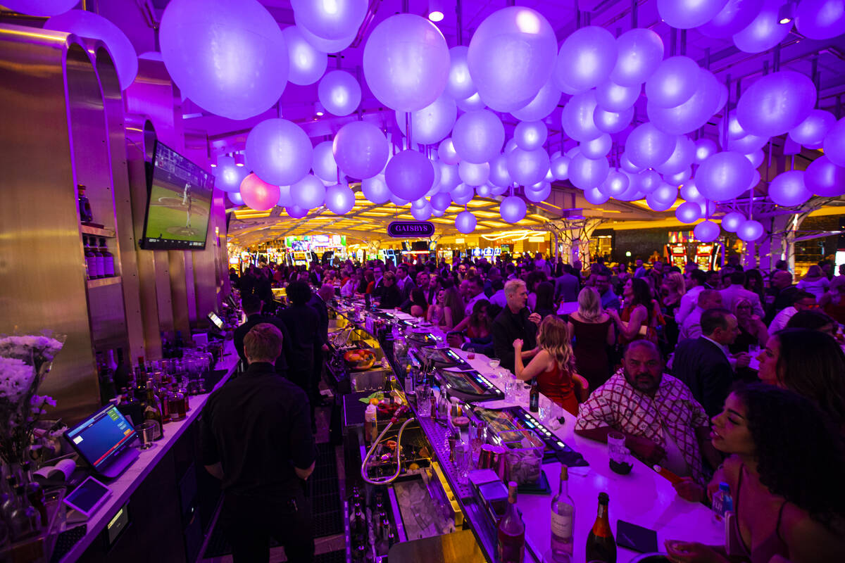 People drink and mingle at Gatsby's cocktail lounge during the opening night of Resorts World L ...