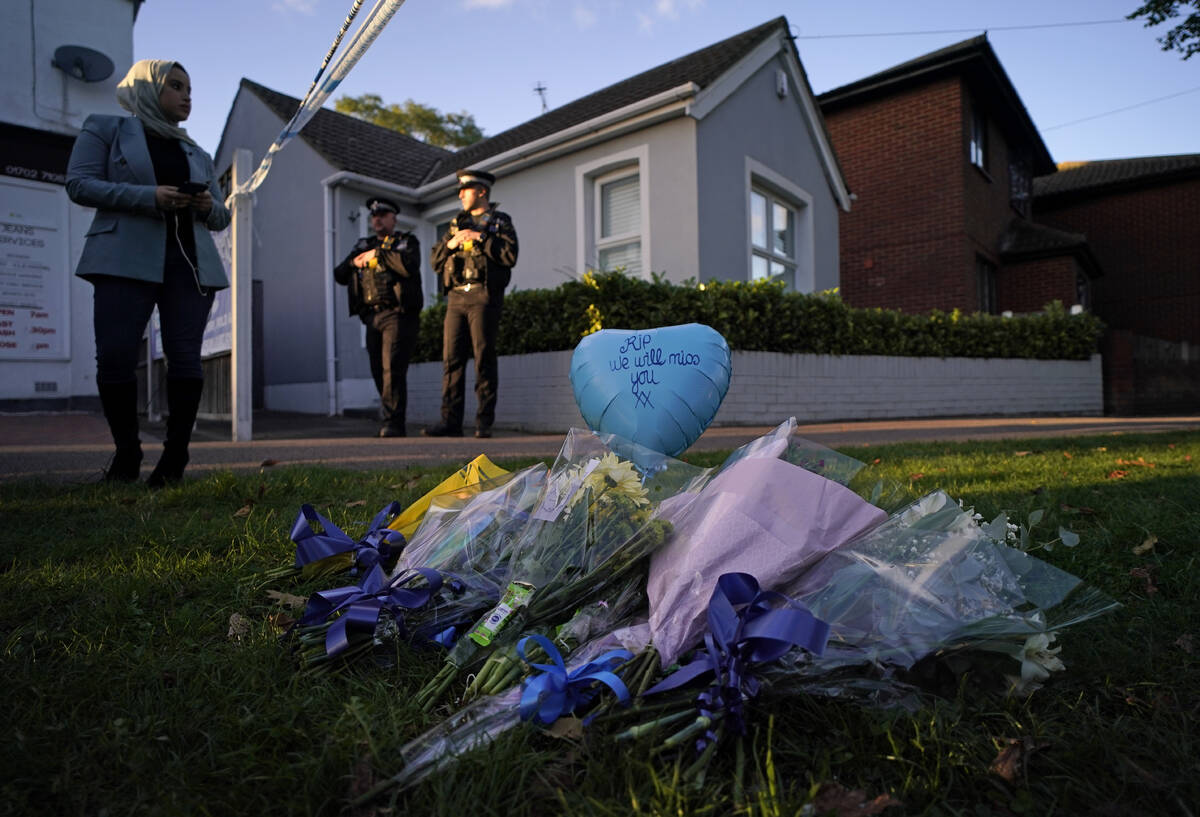 Floral tributes can be seen as police officers block one of the roads leading to the Belfairs M ...