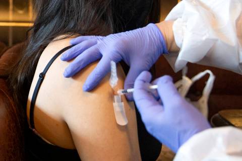 Audrey Vallapudua, of Las Vegas, receives the Pfizer COVID-19 vaccine during a pop-up vaccinati ...