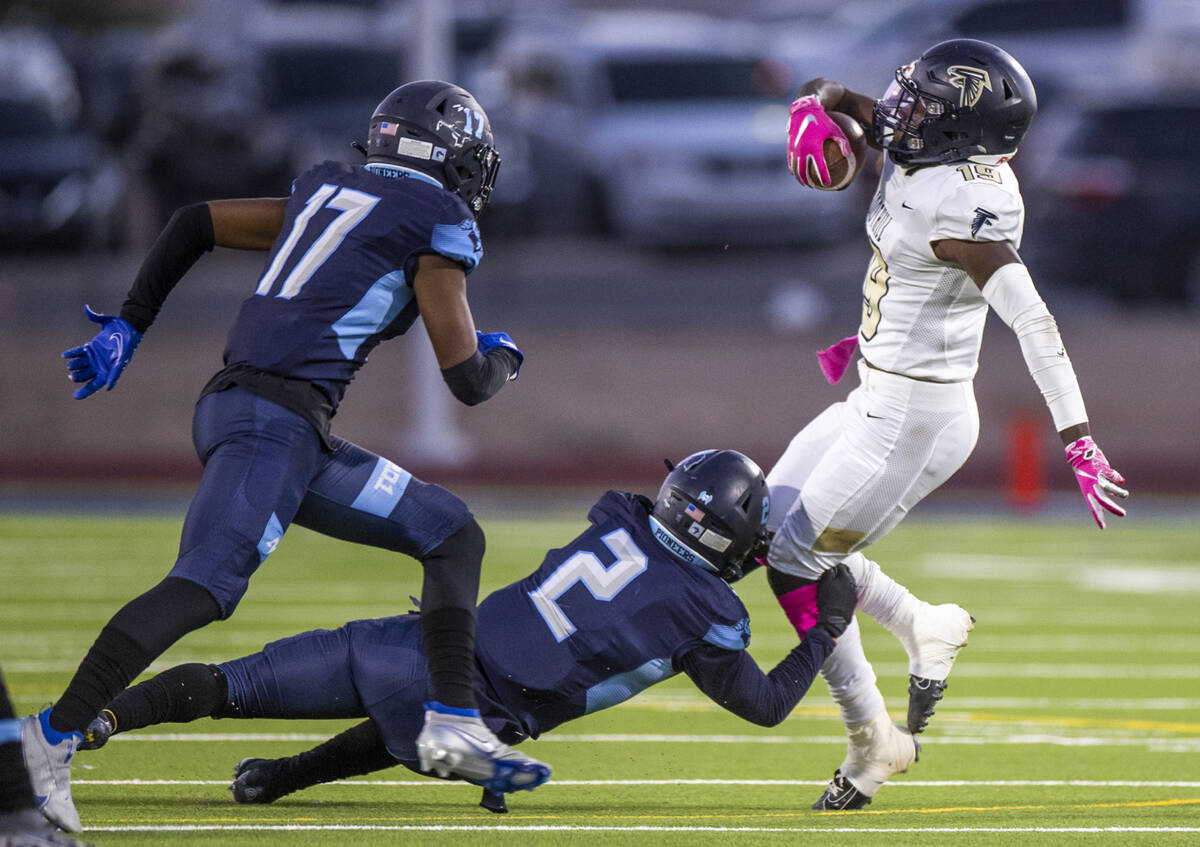 FoothillÕs Kendric Thomas (19, right) is tackled by Canyon SpringsÕ Luis Ortega (2) w ...