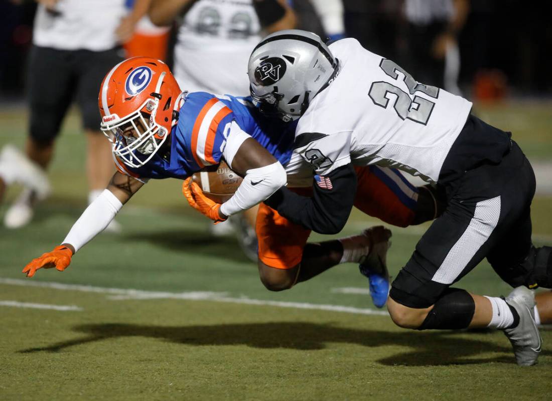 Bishop Gorman High School's Devon Rice (28) is tackled by Palo Verde High School's Jake Fields ...
