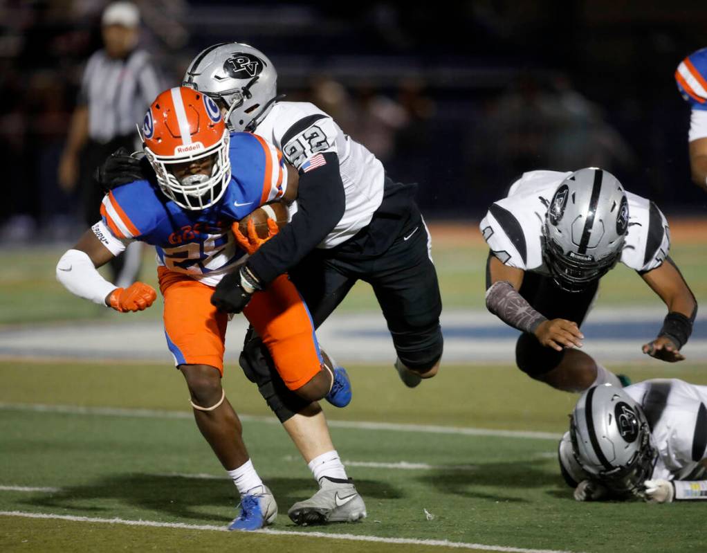 Bishop Gorman High School's Devon Rice (28) is tackled by Palo Verde High School's Jake Fields ...
