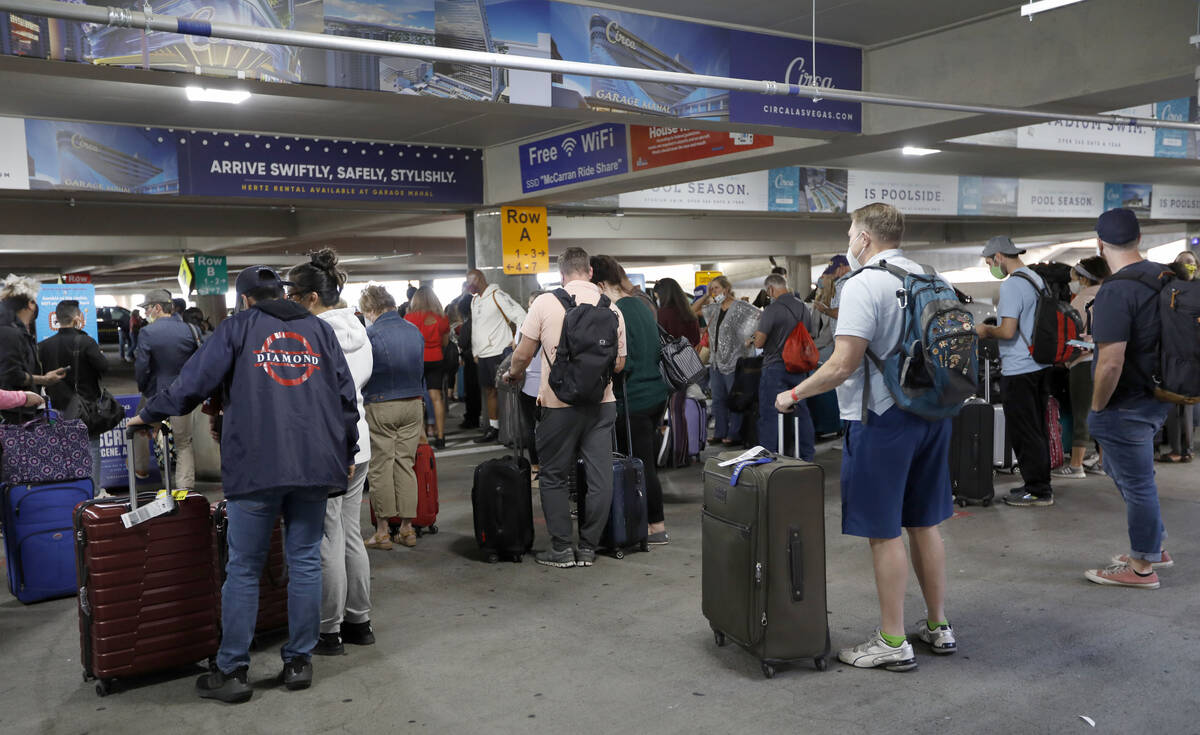 Arriving passengers wait in the pickup area for ride-sharing services at McCarran International ...