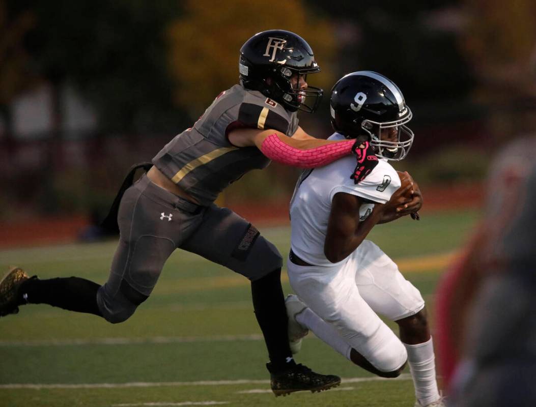Faith Lutheran School's Blake Driscoll (6) tries to stop Desert Pines High School's Michael Kea ...