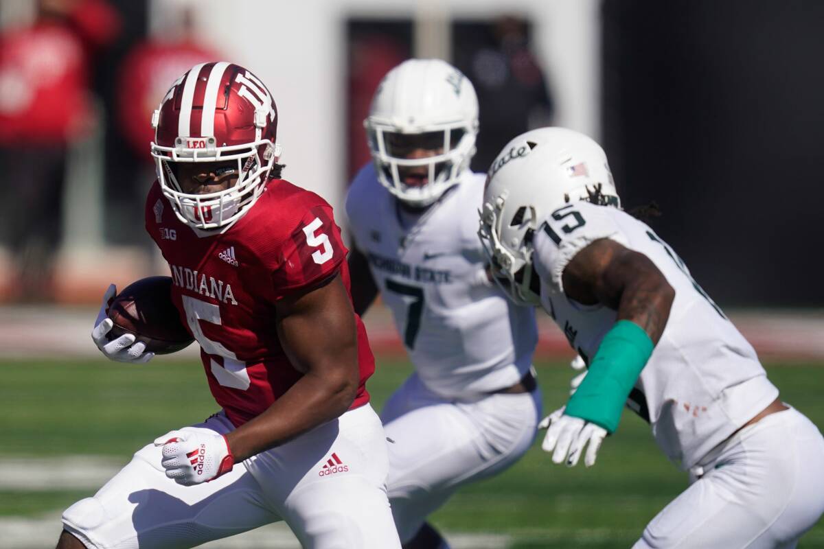 Indiana's Stephen Carr (5) is tackled by Michigan State's Angelo Grose (15) during the first ha ...