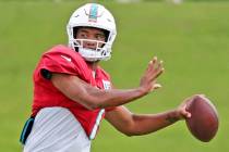 Miami Dolphins quarterback Tua Tagovailoa (1) sets up to pass during NFL football practice in M ...