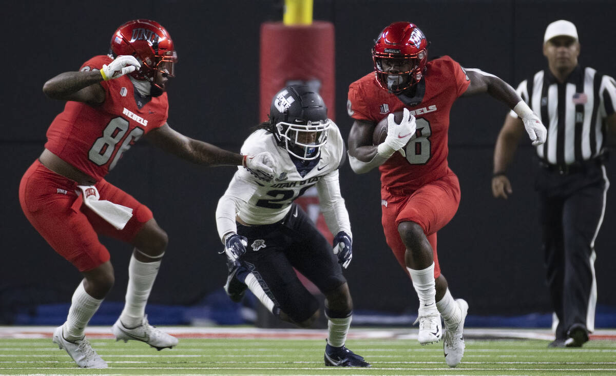 Rebels running back Charles Williams (8) sprints up field past Utah State Aggies safety Monte' ...