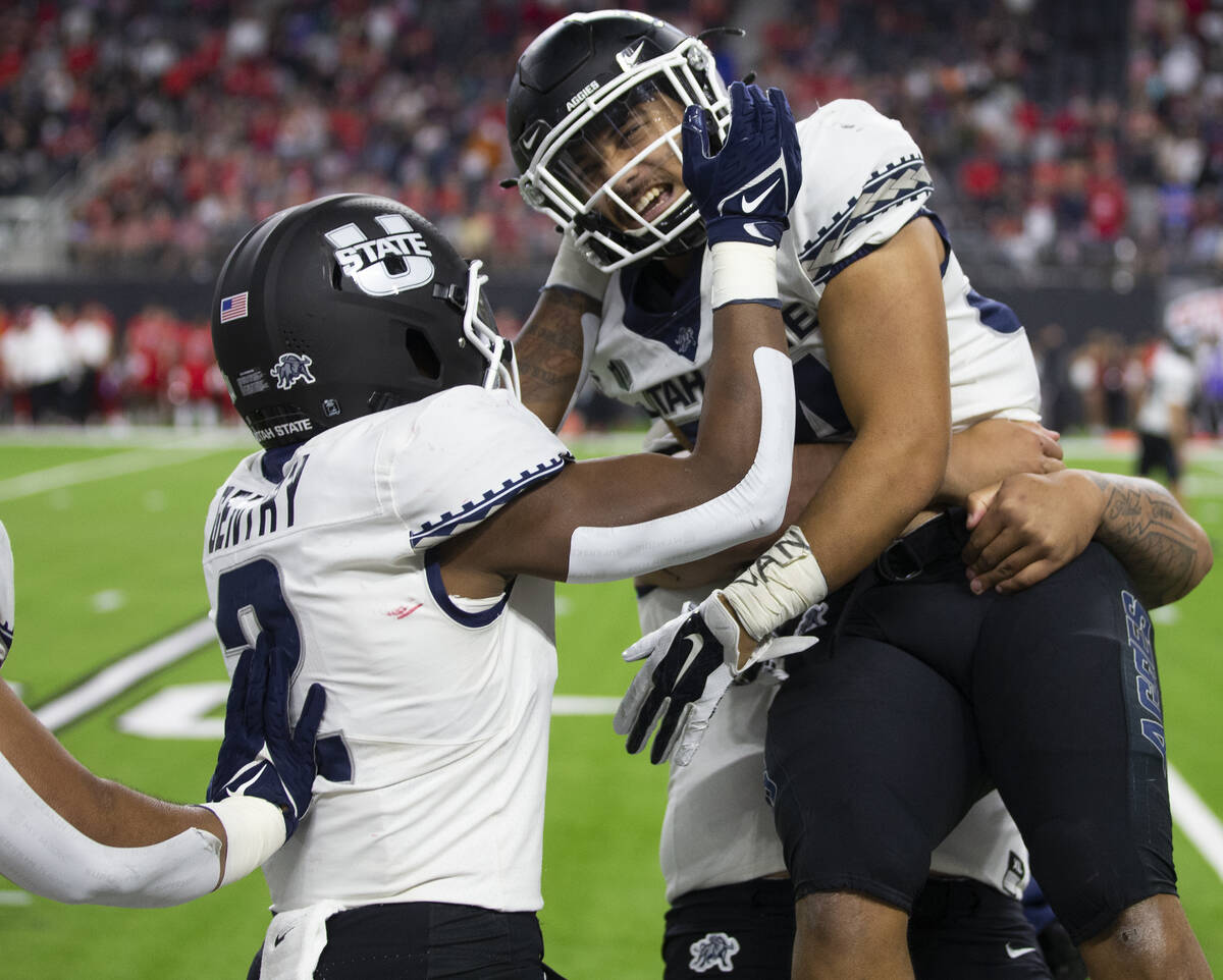 Utah State Aggies running back Elelyon Noa (34) celebrates with Utah State Aggies running back ...