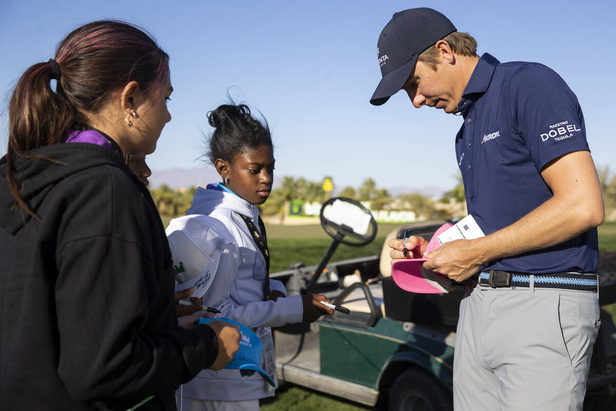 Carlos Ortiz signs an autograph for 11-year-old Ejine Nwapa, center, of Las Vegas, after he com ...