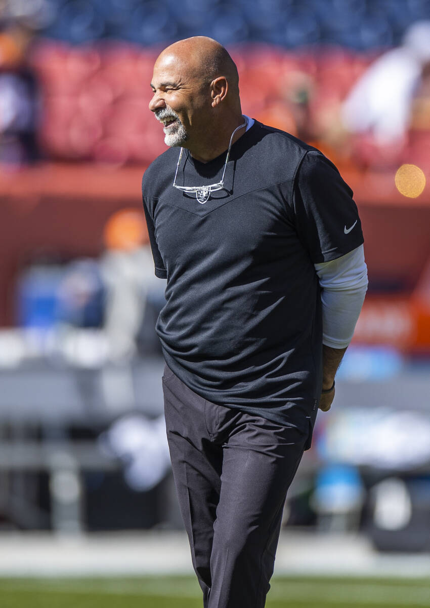 Raiders interim head coach Rich Bisaccia laughs with players before the first half of an NFL ga ...