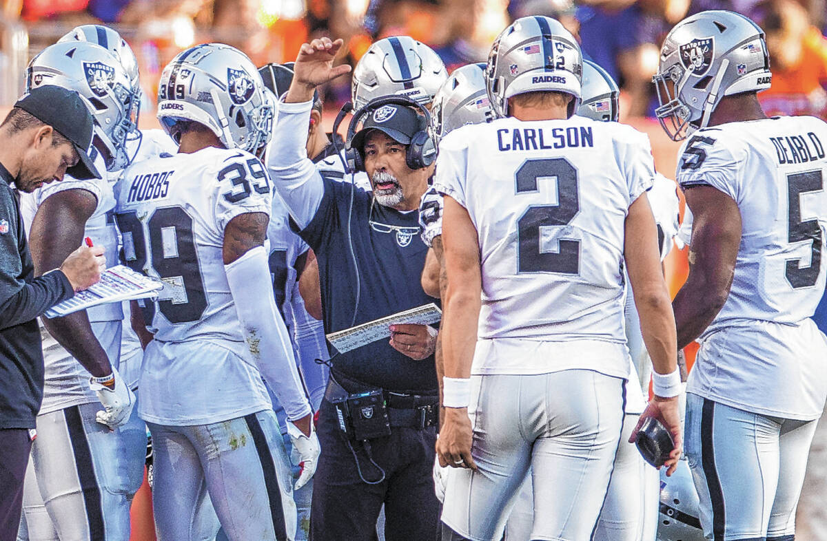 Raiders' interim head coach Rich Bisaccia makes a call in a timeout huddle versus the Denver Br ...