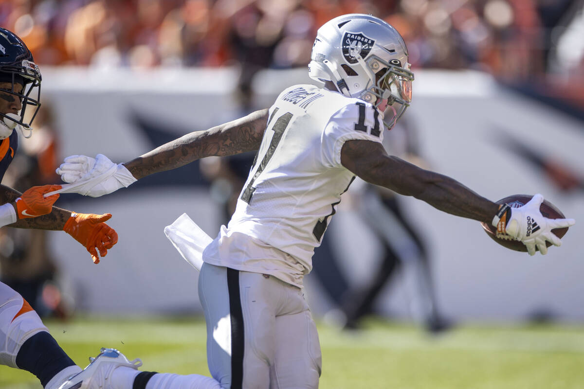 Raiders' wide receiver Henry Ruggs III (11) extends the ball over the goal line versus the Denv ...