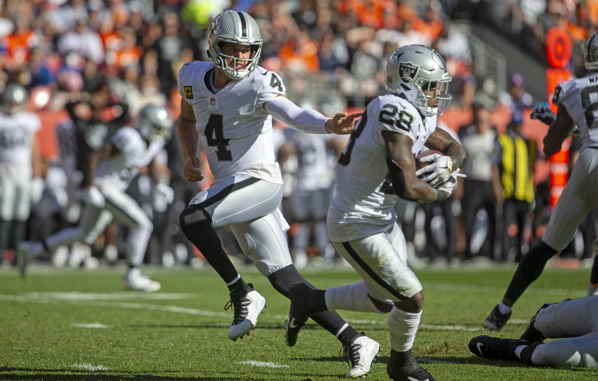 Raiders quarterback Derek Carr (4) hands the football off to Raiders running back Josh Jacobs ( ...