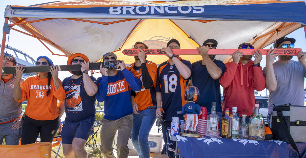Denver Broncos fans all drink shots together in the tailgate area before the first half of an N ...