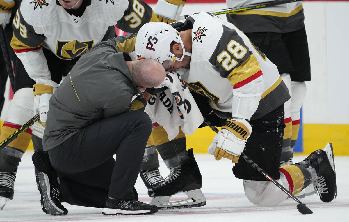 Vegas Golden Knights left wing William Carrier (28) is looked at by a trainer after taking a sk ...