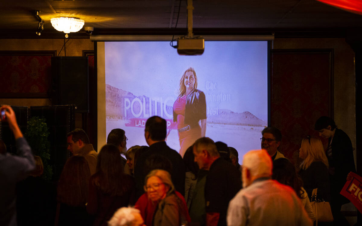 Supporters of Las Vegas Councilwoman Michele Fiore walk by a video campaign ad after she announ ...