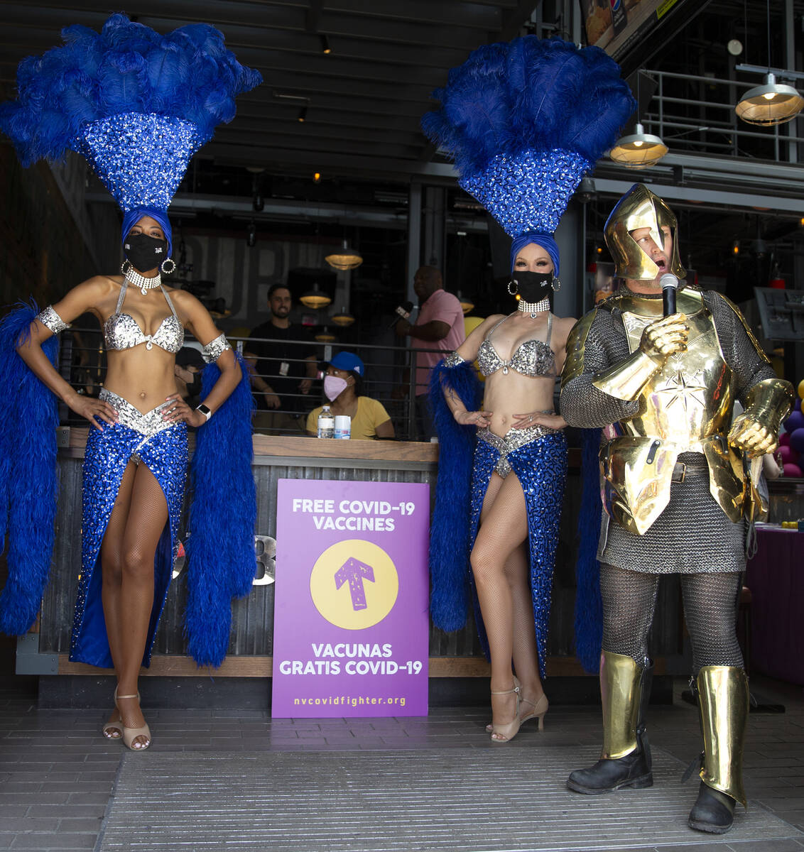 Showgirls and a Vegas Golden Knight encourage passersby to get a free COVID-19 vaccination duri ...